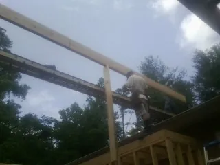 Carpenter setting a ridge beam over a new addition frame — Ice Dam Removal by Roofing Brothers in Fallentimber