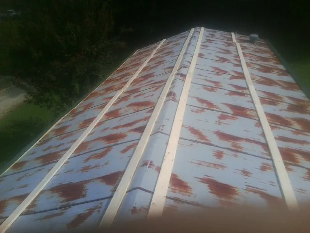 Rusted metal roof panels with new wood purlins before replacement — Storm Damage Roof Repair in Fallentimber by Roofing Brothers