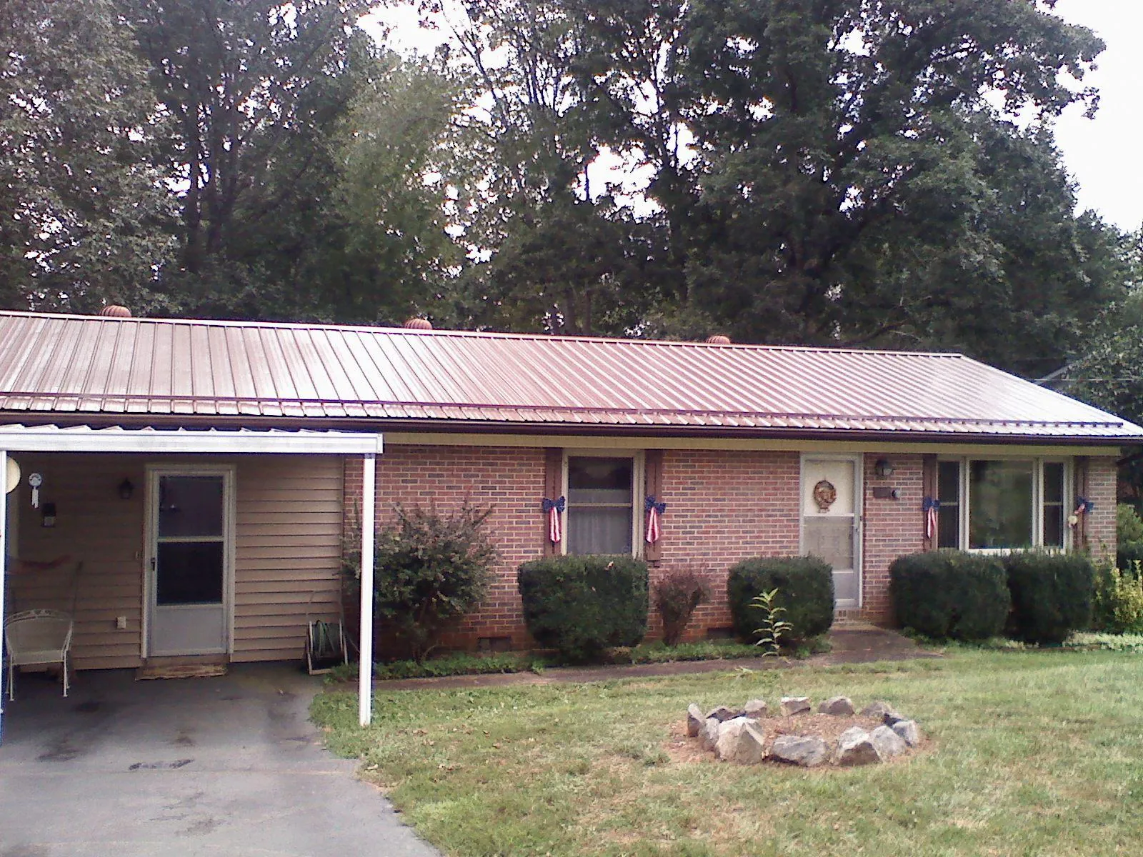 Bronze metal roof and carport on a brick ranch home — Roof Repair work by our crew in Fallentimber
